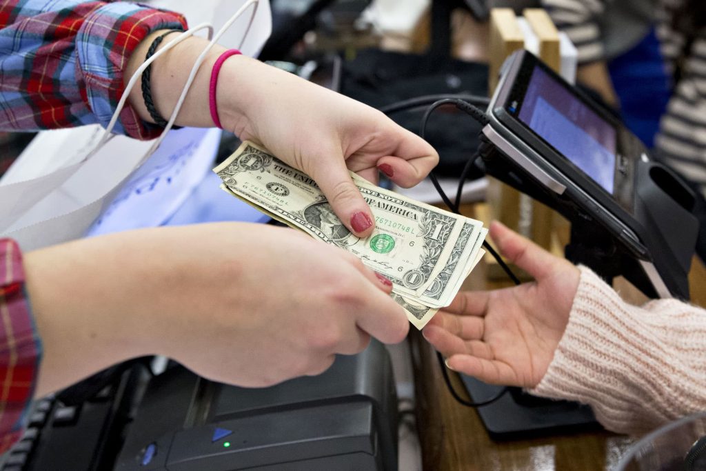 two people exchanging money at a cash register