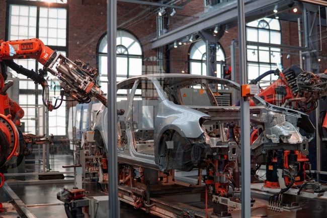 an assembly line with robots working on a car