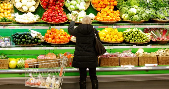 edit106473821-1585931052853woman-makes-purchases-in-the-store-novelty-consultation-woman-adult-fashion-consumer-indoor-human_t20_2j43do a woman standing in front of a display of fruits and vegetables