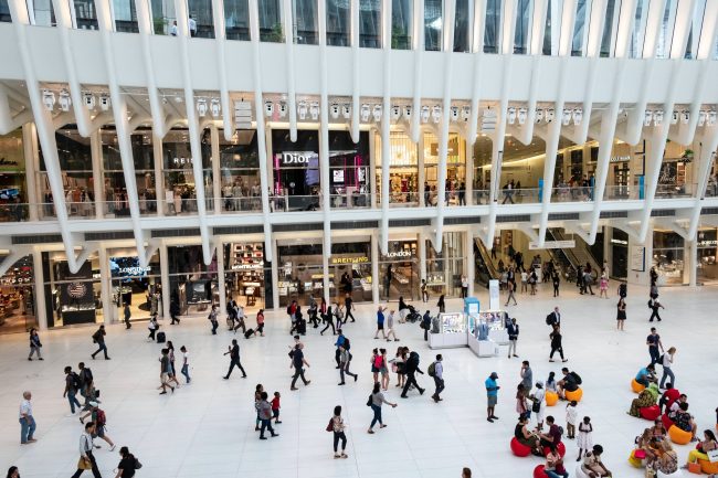 a large group of people walking around a mall